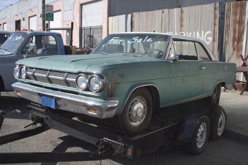 Classic car on a trailer with "For Sale" sign