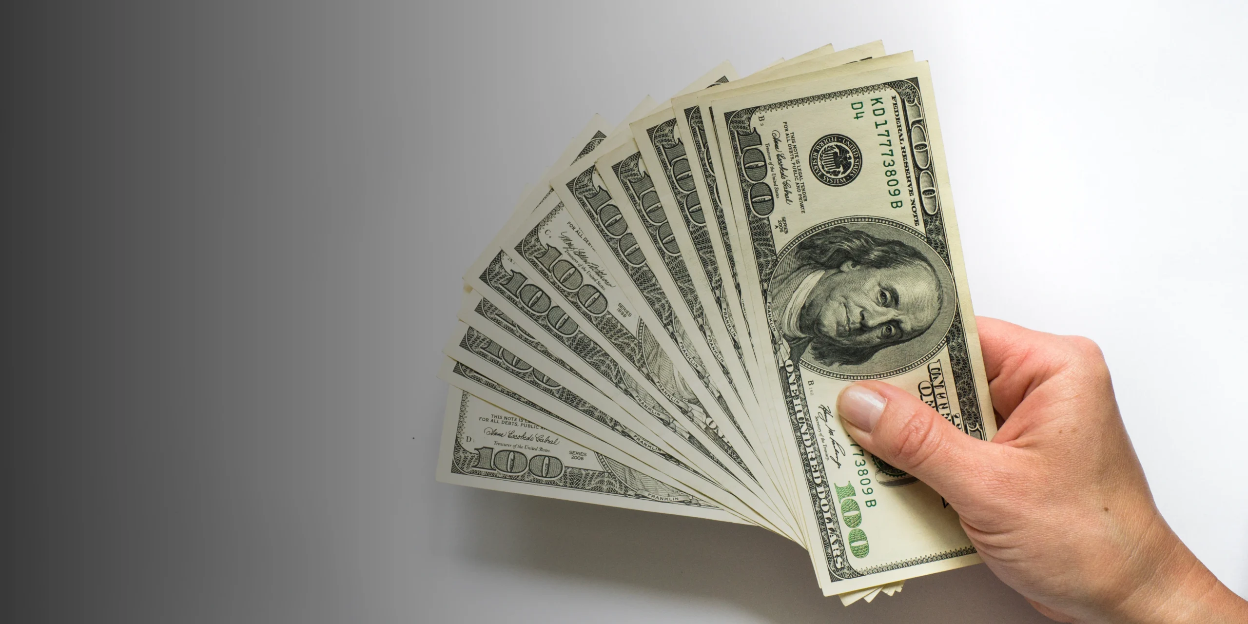 Close-up of hands exchanging stacks of U.S. dollars